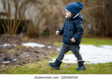 Funny Toddler Boy Having Fun Outdoors On Chilly Winter Day. Child Exploring Nature. Winter Activities For Small Kids.