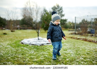 Funny Toddler Boy Having Fun Outdoors On Chilly Winter Day. Child Exploring Nature. Winter Activities For Small Kids.