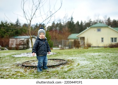 Funny Toddler Boy Having Fun Outdoors On Chilly Winter Day. Child Exploring Nature. Winter Activities For Small Kids.