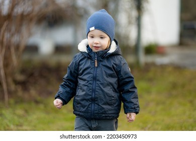 Funny Toddler Boy Having Fun Outdoors On Chilly Winter Day. Child Exploring Nature. Winter Activities For Small Kids.