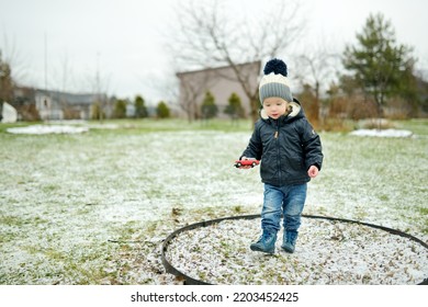 Funny Toddler Boy Having Fun Outdoors On Chilly Winter Day. Child Exploring Nature. Winter Activities For Small Kids.