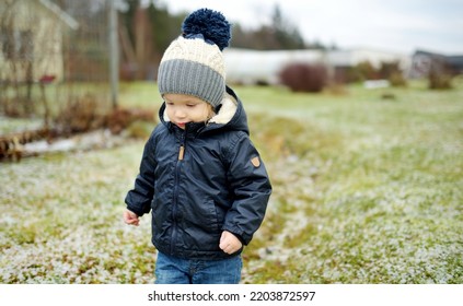 Funny Toddler Boy Having Fun Outdoors On Chilly Winter Day. Child Exploring Nature. Winter Activities For Small Kids.