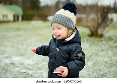 Funny Toddler Boy Having Fun Outdoors On Chilly Winter Day. Child Exploring Nature. Winter Activities For Small Kids.