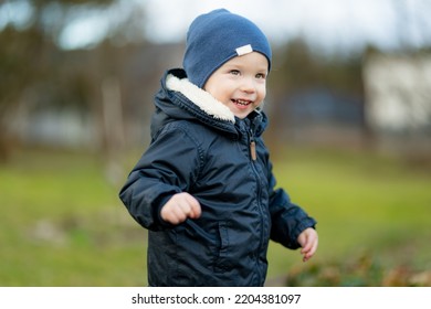 Funny Toddler Boy Having Fun Outdoors On Chilly Winter Day. Child Exploring Nature. Winter Activities For Small Kids.