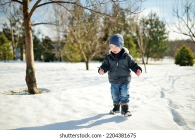 Funny Toddler Boy Having Fun Outdoors On Chilly Winter Day. Child Exploring Nature. Winter Activities For Small Kids.