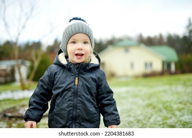 Funny Toddler Boy Having Fun Outdoors On Chilly Winter Day. Child Exploring Nature. Winter Activities For Small Kids.