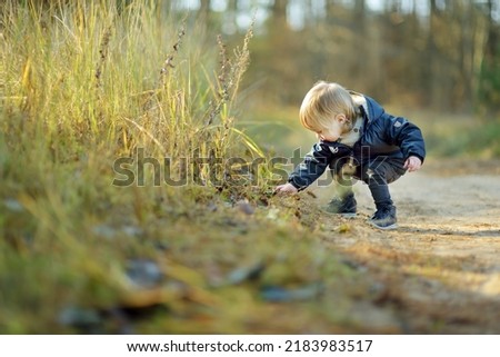 Similar – Image, Stock Photo Sun always shines after the rain. Small bond infant boy wearing yellow rubber boots and yellow waterproof raincoat walking in puddles in city park on sunny rainy day.