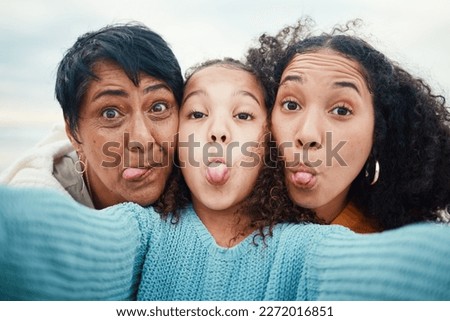 Funny, tongue out and portrait of a family selfie, silly and goofy at the beach in Bali. Comic, and girl taking a photo with a mother and grandmother for a playful memory on holiday at the sea