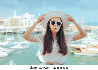
Funny Tourist Girl Visiting a Landmark Harbor. Cheerful tourist adjusting her sunhat visiting beautiful bay
