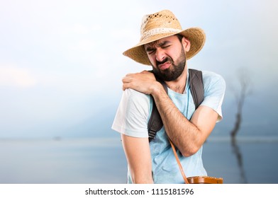 Funny tourist with shoulder pain in a beautiful landscape