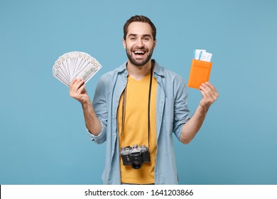 Funny Traveler Tourist Man In Yellow Clothes With Photo Camera Isolated On Blue Background. Passenger Traveling On Weekends. Air Flight Journey. Hold Passport Boarding Pass Tickets Fan Of Cash Money