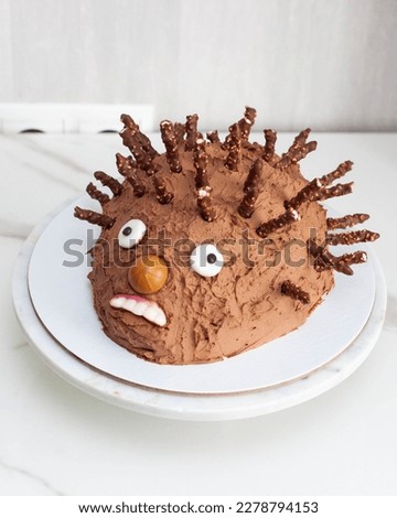 Funny ugly hedgehog cake for children's birthday made of chocolate and sweets