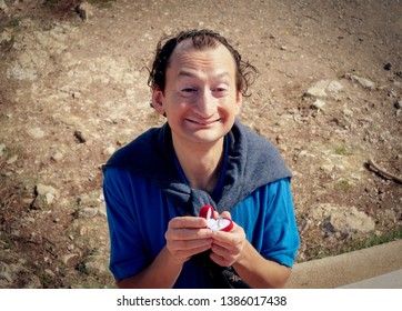 A Funny Ugly Man Making A Marriage Proposal By Offering A Wedding Ring. Even The Rocky Background Is Unattractive. Comedy Shot.
