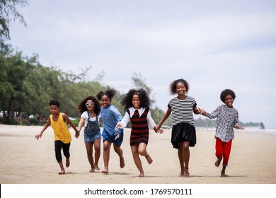 Funny Vacation. Children Or Kids Playing And Romp Together At The Beach On Holiday. Having Fun After Unlocking Down The City From COVID19. Seven African American Kids. Ethnically Diverse Concept	
