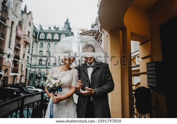 Funny Wedding Couple Poses Under Transparent Stock Image