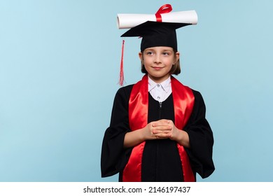 Funny Whizz kid girl wearing graduation cap and ceremony robe with certificate diploma on light blue background. Graduate celebrating graduation. Education Concept. Successful elementary school