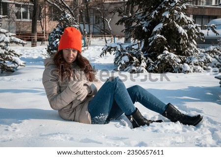 funny winter woman in warm hat sit in snow wintertime. winter fashion of woman in warm hat with wintertime snow.
