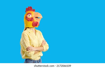 Funny Woman In Chicken Head Rubber Mask Isolated On Blue Studio Background. Cool Girl In Eccentric Headgear For Celebration Or Party. Entertainment And Fun Concept.