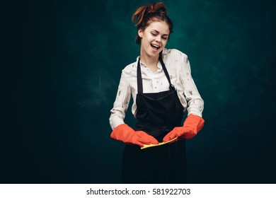 Funny woman cleans the house, rag in hand, rubber gloves, bright background