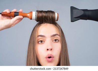 Funny woman close up face combing hair and dryer hair with hairdryer. Portrait of female model with a comb brushing hair. Girl with with hairdryer, hair care and beauty.