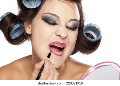 Funny Woman With Curlers And Bad Makeup Applied Lip Pencil