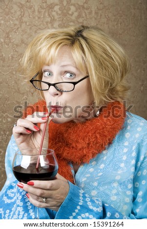 Funny woman drinking wine through a straw