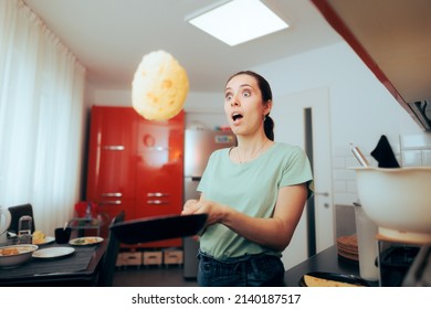 
Funny Woman Flipping Pancakes in the Kitchen. Home cook making breakfast testing crepe tossing skills in the morning
 - Powered by Shutterstock