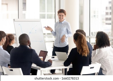 Funny woman leader consulting diverse group at meeting room, boss mentor coach at negotiation, corporate colleague training at boardroom.