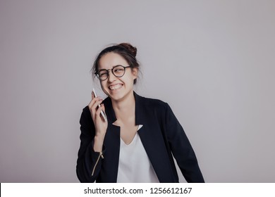   Funny Woman Make Fun Of Someone By Phone. The Girl Is Laugh With Wide Toothy Smile On The Her Face