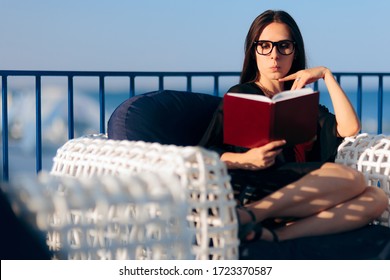 Funny Woman Reading On A Terrace Balcony. Curious Girl With Mystery Novel Spending Her Free Time
