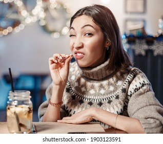 Funny Woman Smiles, Winks And Picks Her Teeth With A Toothpick On A First Date. Concept Of Bad Manners And Bad Habits, As Well As Dental Health