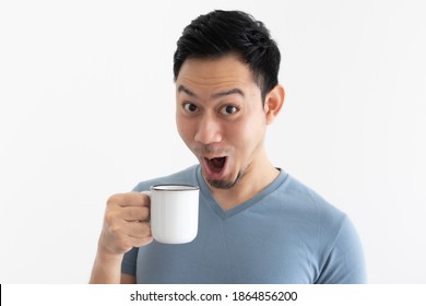 Funny Wow Face Of Asian Man In Blue T-shirt Drinks Coffee From White Mug.