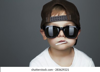 Funny Young Boy Eating A Lollipop.Fashionable child in sunglasses