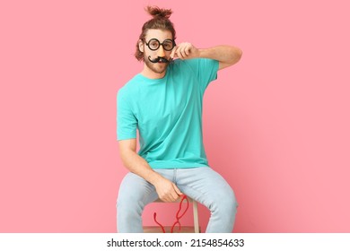 Funny Young Man In Disguise On Pink Background. April Fools' Day Celebration