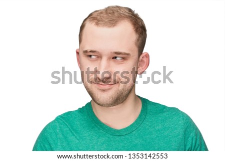 A funny young man in a green shirt shows emotion