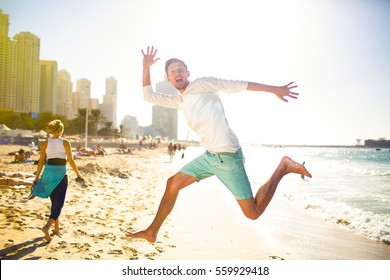 Funny Young Man In White Hoodie Jumps Up On Beach In Dubai