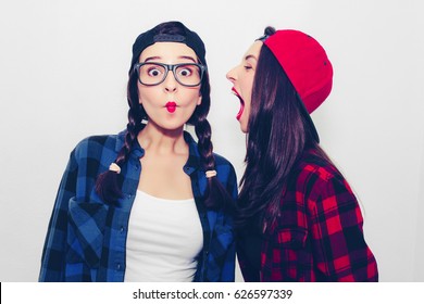 Funny young woman crazy shouting scream to another one. Colorful comic funny emotional hipster summer style twins teenager girls screaming, make faces and have fun. Isolated on a grey background