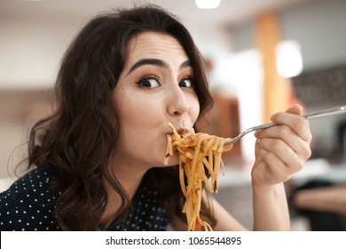 Funny Young Woman Eating Tasty Pasta In Cafe