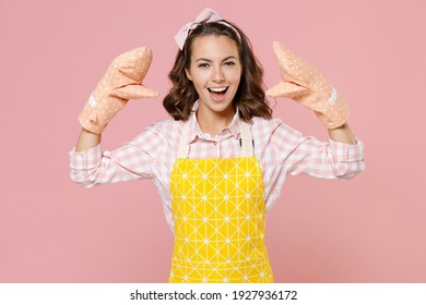 Funny Young Woman Housewife In Yellow Apron Gloves Potholders Showing Blah Blah Gesture Ja Jaja Hands While Doing Housework Isolated On Pastel Pink Background Studio Portrait. Housekeeping Concept