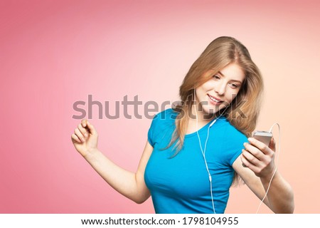 Funny young woman listening to music with headphones