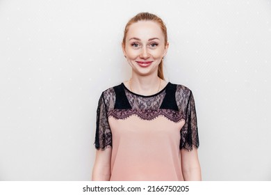 a funny young woman with long hair in a black and pink blouse with lace. female portrait. beautiful home clothes. eyelash extensions and lip augmentation.