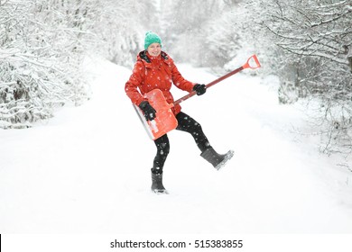 Funny Young Woman On Winter Street Holding Snow Shovel Like A Guitar