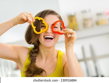 Funny young woman showing slices of bell pepper