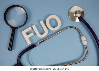 FUO Fever Of Unknown Origin text with Stethoscope and magnifying glass on blue background