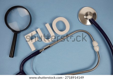 FUO Fever Of Unknown Origin text with Stethoscope and magnifying glass on blue background