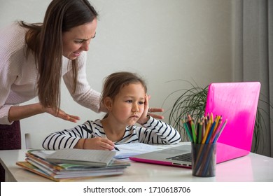 Furious adult woman screaming at daughter while she helping to do her homework assignment at home