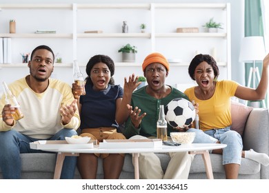 Furious African American Friends Drinking Beer And Eating Snacks, Watching Football Game On TV At Home Together. Angry Black Men And Women Fans Watching Sport Match, Gesturing And Screaming
