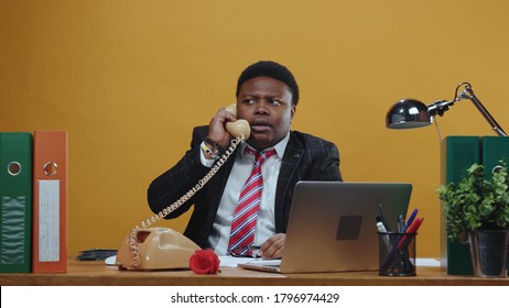 Furious Angry Black Businessman Boss Shouting And Arguing On Telephone Call Conversation Yelling At Employee Working At Desk In Company Office. Bad Day.