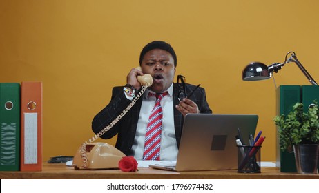 Furious Angry Black Businessman Boss Shouting And Arguing On Telephone Call Conversation Yelling At Employee Working At Desk In Company Office. Bad Day.