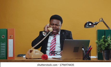 Furious Angry Black Businessman Boss Shouting And Arguing On Telephone Call Conversation Yelling At Employee Working At Desk In Company Office. Bad Day.